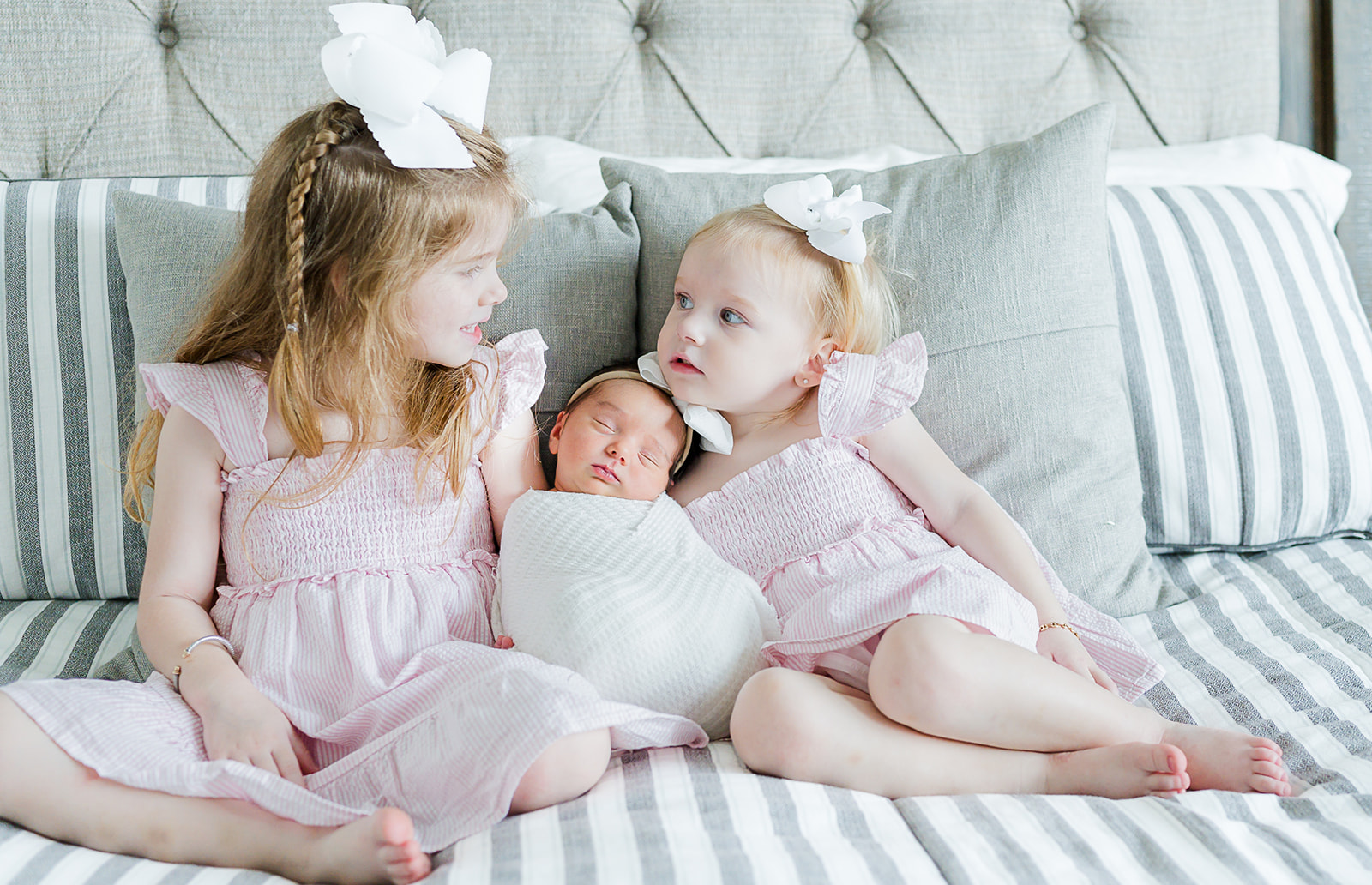 Sisters snuggle during their in home lifestyle newborn photography session